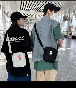 Detalle de bolso bandolera de nailon con logo S llevado por pareja en entorno casual