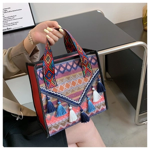 Dettaglio borsa tessuta bohémien con motivi geometrici colorati e nappe blu alla moda
