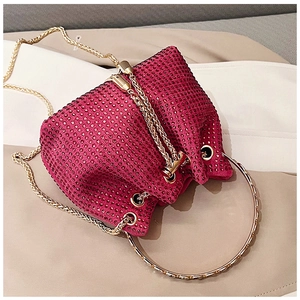 Close-up of fuchsia rhinestone bucket bag with gold ring handle and chain strap