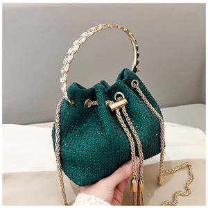 Detail of dark green rhinestone bucket bag with gold crystal leaf handle and chain