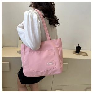 Detailed close-up of a pink nylon tote bag with fashion tag and large front pocket