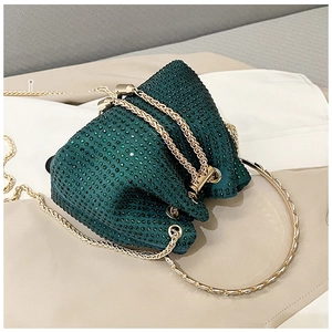 Detail of dark green rhinestone bucket bag with golden ring handle and chain strap