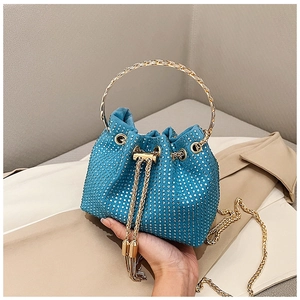 Detail view of blue rhinestone bucket bag with golden circular handle and tassel drawstring