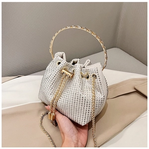 Detail of the sparkling silver rhinestone bucket bag with a golden metal round handle