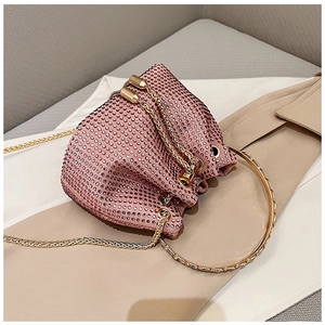 Detail of pink rhinestone bucket bag with golden ring handle and elegant snake chain