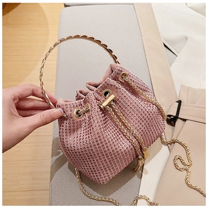 Detail of pink rhinestone drawstring bucket bag with gold handle and chain strap