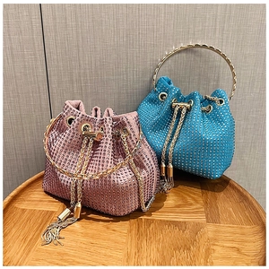 Detail of pink and blue rhinestone bucket bags with gold ring handles and chain tassels