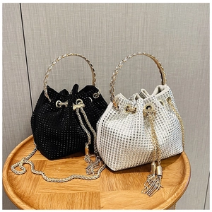 Detail of luxury rhinestone bucket bags in black and silver with chain straps
