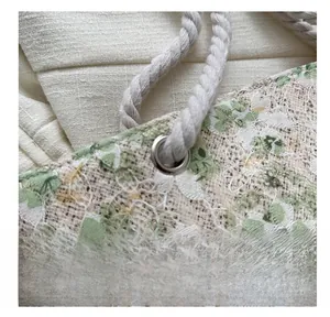 Close-up of intricate white lace embroidery and floral patterns on cotton tote bag