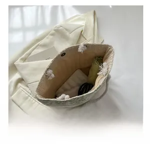 Top view of the floral straw tote bag showing interior space with an umbrella and wallet