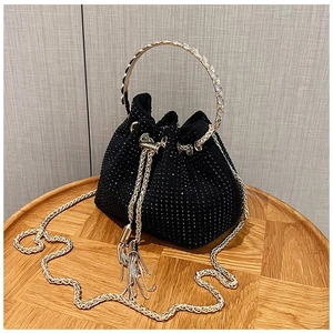Detail shot of black rhinestone bucket bag featuring gold ring handle and tassel drawstring