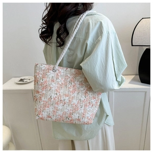 Detail of floral tote bag featuring white cotton rope handles and silver metal eyelets