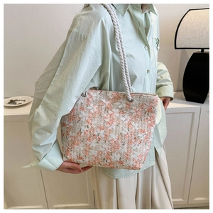 Detailed close-up of a floral canvas tote bag with thick cotton rope handles and metal eyelets