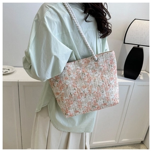 Lifestyle view of large floral lace woven tote bag with white rope handles on model