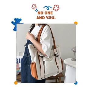 Detail view of canvas tote bag showing contrast color design and large storage pockets
