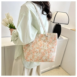 Detail of floral tote bag featuring white rope handles and lace-style canvas texture