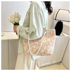 Detailed close-up of lace straw tote bag with floral patterns and cotton rope handles