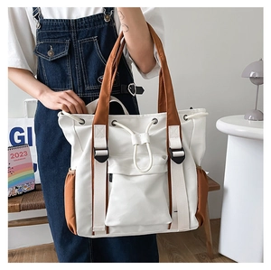Detail view of large white tote bag with side pockets and functional drawstring closure