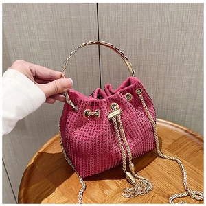 Detail of rose red rhinestone bucket bag with gold ring handle and drawstring chain