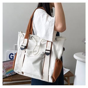 Detail of cargo-style tote bag with contrast brown straps and drawstring closure
