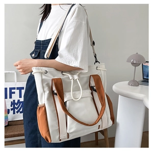 Detail of multi-functional large capacity tote bag with drawstring side pocket and dual straps