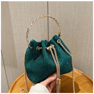 Detail of green rhinestone bucket bag with gold crystal handle and chain strap
