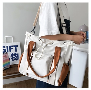 Detail of color-block tote bag featuring side pockets and adjustable shoulder strap
