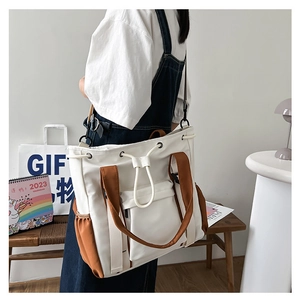 Detail of contrast stitching tote bag with adjustable shoulder straps and side pockets