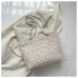 Close-up of crochet tote bag featuring floral embroidery and thick cotton rope handles