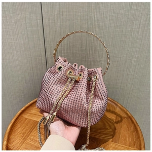 Detail of pink bucket bag with shimmering rhinestones, gold ring handle and chain