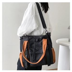 Detail of contrast-color tote bag with drawstring closure and side pockets for school