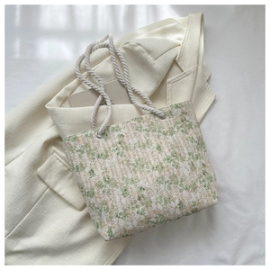 Detailed macro view of the floral lace texture and sturdy white rope handle of the tote bag