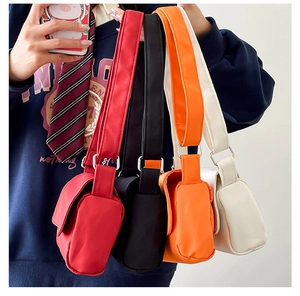 Detailansicht der bunten Nylon-Schultertaschen in Rot, Schwarz, Orange und Weiß