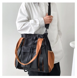 Detail view of large contrast tote bag showing drawstring closure and side pockets