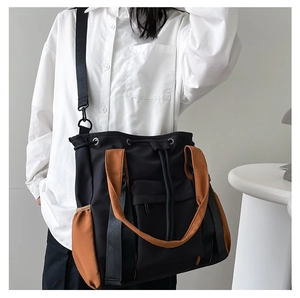 Model wearing a large contrast-color tote bag with adjustable shoulder strap for daily use