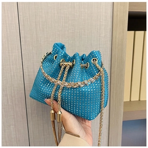 Detail of peacock blue bucket bag showing sparkling rhinestones and golden tassels