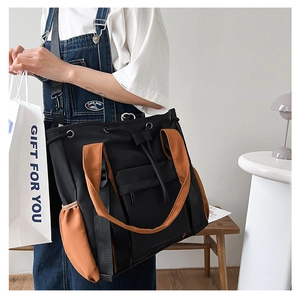 Macro view of nylon tote bag showing black and brown contrast panels and side pockets