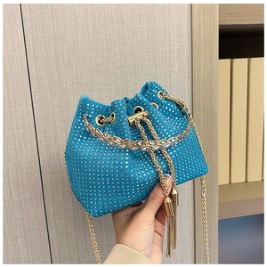 Detail of luxury lake blue rhinestone bucket bag with gold chain and leaf crystal trim