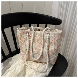 Close-up of floral lace tote bag with thick cotton rope handles on a black chair