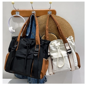 Detailed view of large nylon tote bags with drawstring closure and contrast side pockets