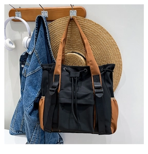 Detail of contrast color tote bag showing drawstring closure and durable nylon material