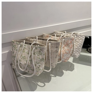Close-up of four floral lace tote bags with rustic cotton rope handles in various colors