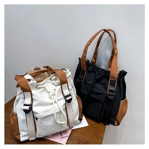 Detail view of multi-functional drawstring tote bag with contrast straps and pockets