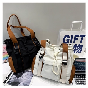 Detailed view of two-tone bucket bags featuring drawstring closure and buckle straps