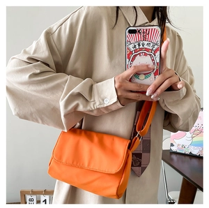 Nahaufnahme der leuchtend orangen Umhängetasche aus Nylon mit verstellbarem Gurt