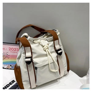 Detail view of large nylon tote bag with drawstring closure and brown contrast straps