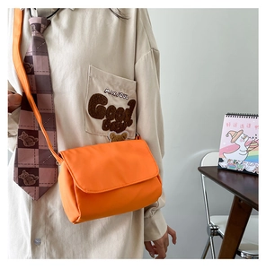 Detail einer minimalistischen leuchtend orangen Umhängetasche mit Klappverschluss für Damen