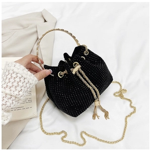 Detailed macro of black rhinestone bucket bag with golden ring handle and tassels
