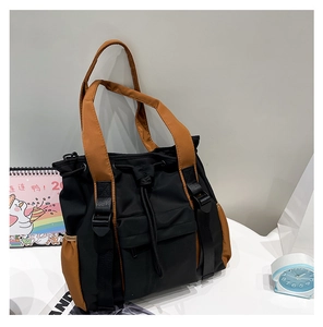 Detail of multi-pocket contrast tote bag with drawstring pocket and utility buckle straps
