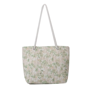 Lace straw tote bag with floral pattern and white rope handles on white background
